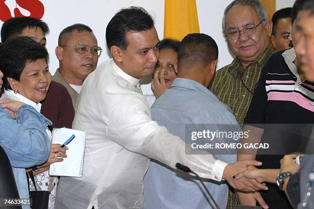 Newly proclaimed senator, detained Philippine navy lieutenant, Antonio Trillanes , followed by his mother Estelita Trillanes shake hands with...