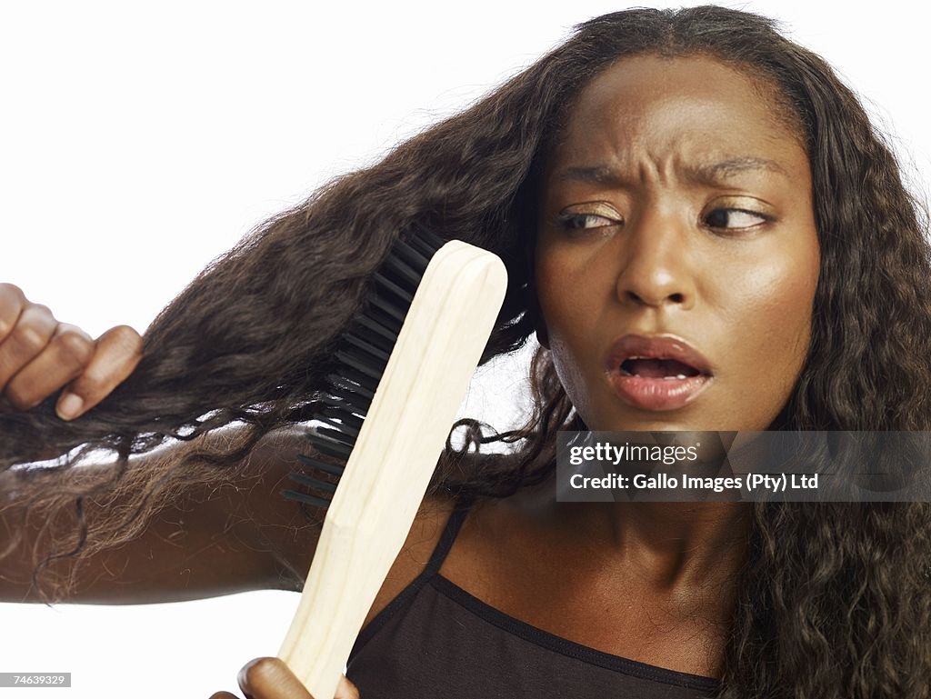Woman Using an Over sized Steel Bristle Brush to Brush Her Hair