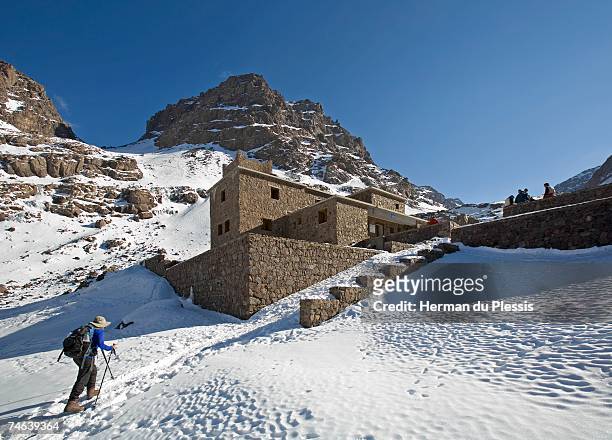 woman hiking in snow up to toubkal refuge - toubkal stock pictures, royalty-free photos & images