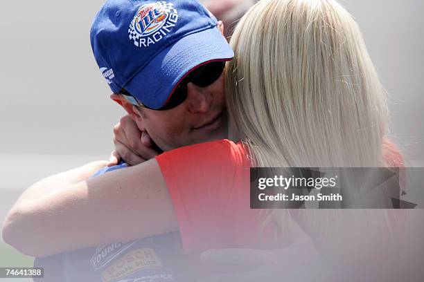 Kurt Busch, driver of the Miller Lite Dodge, hugs his wife Eva, during qualifying for the NASCAR Nextel Cup Series Citizens Bank 400 at Michigan...