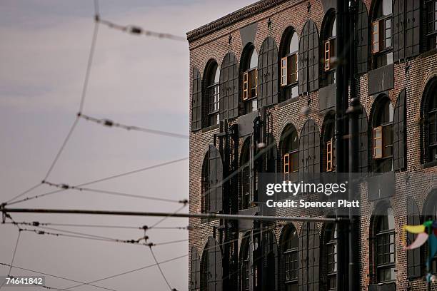 Old trolley cables grace the area in front of a 19th century warehouse, now used as apartments, on the waterfront June 15, 2007 in the Red Hook...