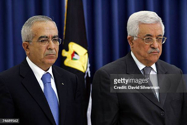 Salam Fayad , the new Palestinian Prime Minister, stands alongside Palestinian President Mahmoud Abbas as Abbas swears in the new government on June...