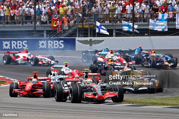 Lewis Hamilton of Great Britain and McLaren Mercedes races as cars crash behind him on the first lap of the F1 Grand Prix of USA at the Indianapolis...