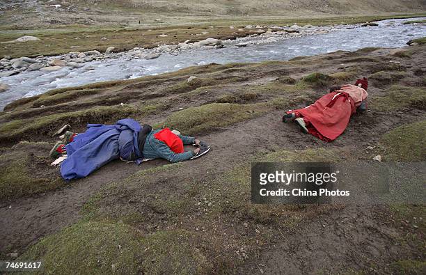 Religious faithful pray at the snow-capped Kangrinboqe Mountain, known as Mt. Kailash in the West, June 16, 2007 in Purang County of Tibet Autonomous...