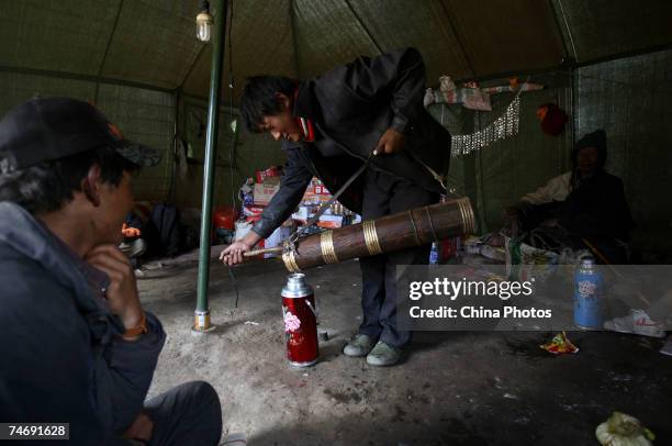 Tibetan nomads make butter tea at the snow-capped Kangrinboqe Mountain, known as Mt. Kailash in the West, June 16, 2007 in Purang County of Tibet...