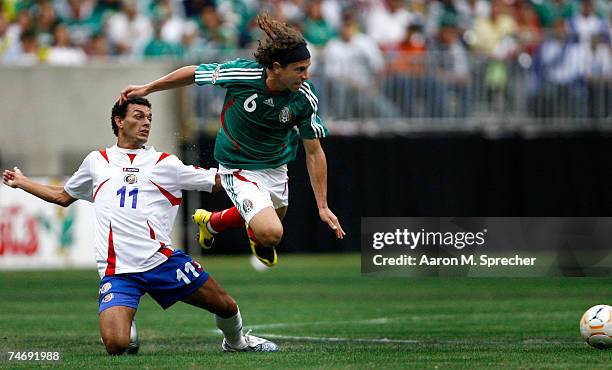 Michael Barrantes of Costa Rica trips up Gerardo Torrado of Mexico during their quarterfinal match of the CONCACAF Gold Cup 2007 tournament on June...