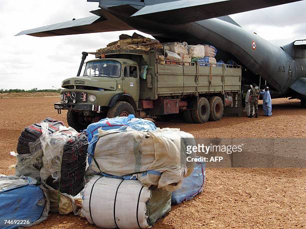 Truck backed up against a French Airforce transport plane is loaded with humanitarian aid at an airstrip just outside Goz Beida, which is 90...