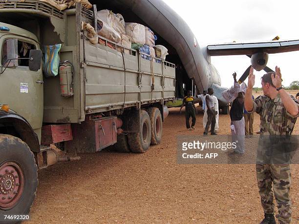 French soldier guides a truck as it backs up against a French Airforce transport plane loaded with humanitarian aid at an airstrip just outside Goz...