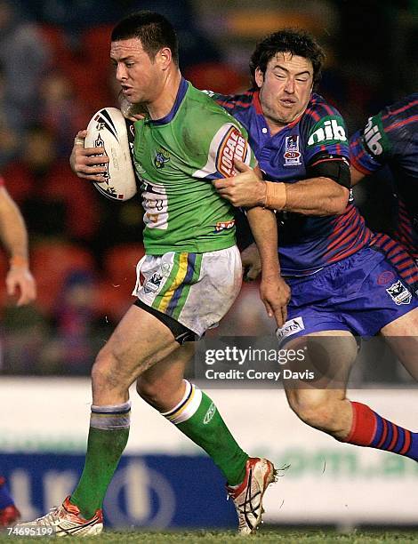 Lincoln Withers of the Raiders is tackled by James McManus of the Knights during the round 14 NRL match between the Newcastle Knights and the...