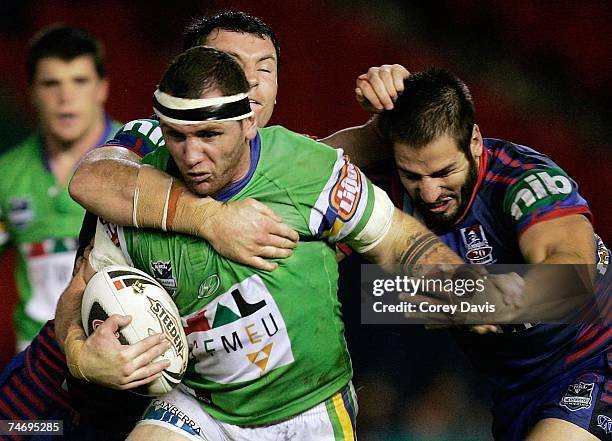 Josh Miller of the Raiders is tackled during the round 14 NRL match between the Newcastle Knights and the Canberra Raiders at EnergyAustralia Stadium...