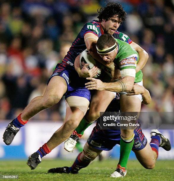 Josh Miller of the Raiders is tackled during the round 14 NRL match between the Newcastle Knights and the Canberra Raiders at EnergyAustralia Stadium...