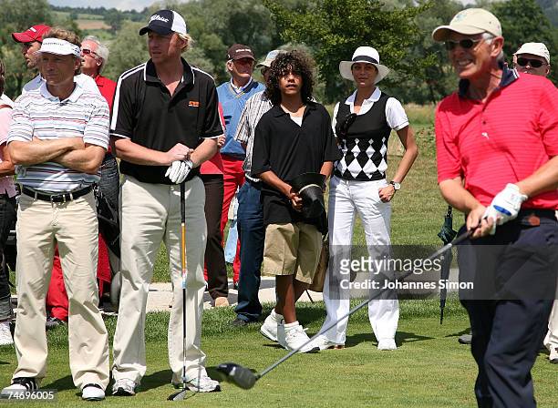 Bernhard Langer and Boris Becker wait on the 18th hole watched by Boris's son Noah and his girlfriend Sharlely Lilly Kerssenberg during the opening...