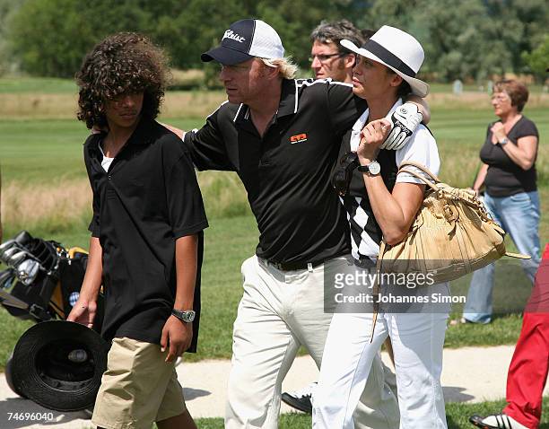 Boris Becker walks across the grounf with his son Noah and his girlfriend Sharlely Lilly Kerssenberg during the opening of Hartl Golf Resort on June...