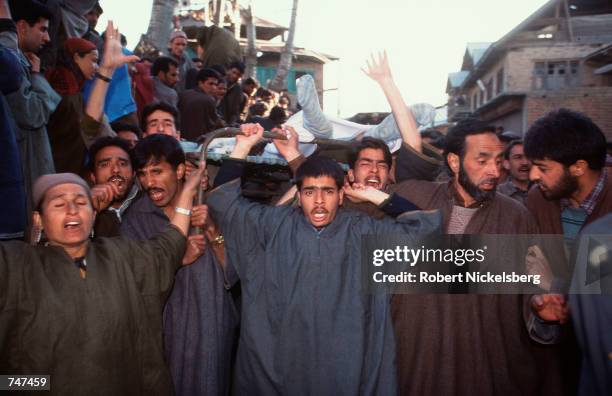 Kashmiris in a frenzy of mourning carry the body of Islamic militan Hamid Gadda, after it is returned to his village in Kashmir, India, March 14,...