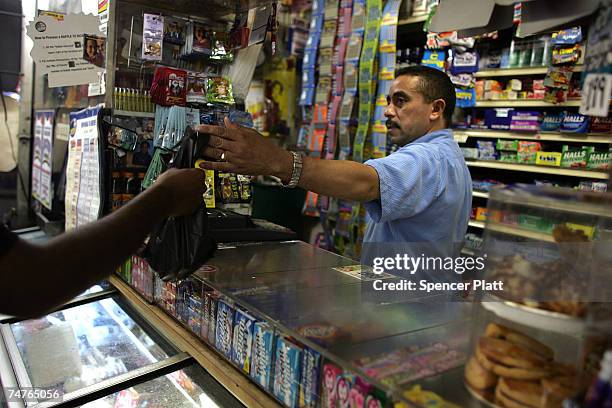 Jesus Martinez works at his bodega grocery store around the corner from where Bolivar Cruz was killed while working at his bodega last week June 18,...