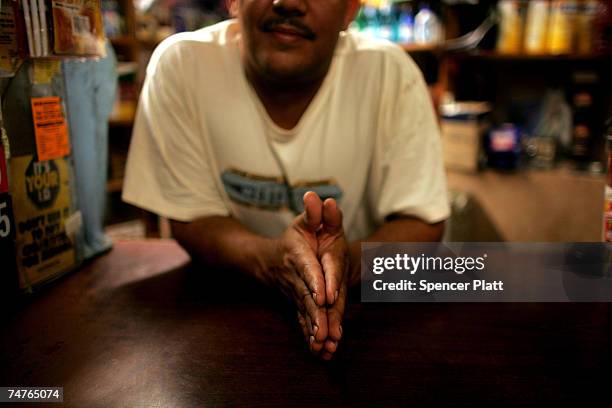 Bodega owner waits for the night to end at a bodega grocery store around the corner from where Bolivar Cruz was killed while working at his bodega...