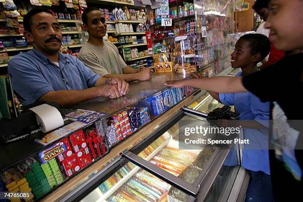 Jesus Martinez works at his bodega grocery store around the corner from where Bolivar Cruz was killed while working at his bodega last week June 18,...