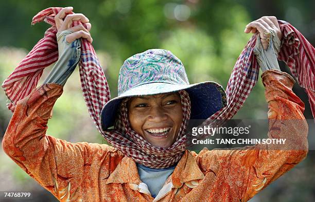 Kampong Cham, CAMBODIA: A Cambodian woman uses a Krama to protect her face from the sunshine at a rice fields in Kampong Cham province, some 60...