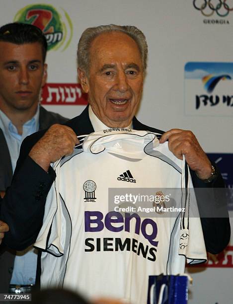 Shimon Peres, President of Israel, poses with Real Madrid official jersey during the presentation of the frienly match between Real Madrid and...