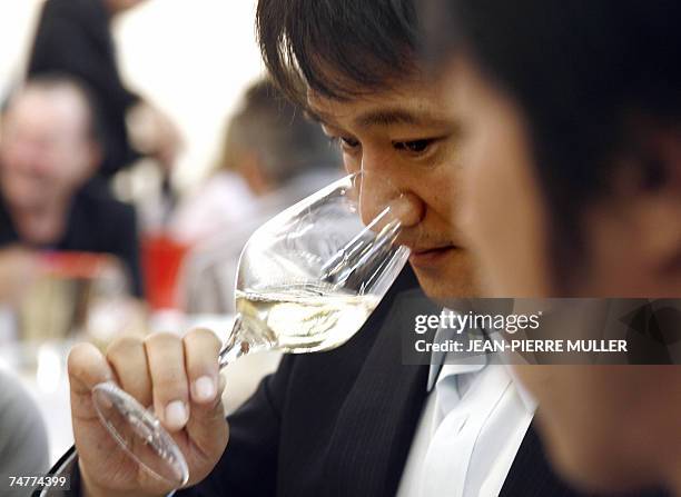 Wine taster sniffs a white wine, 19 June 2007 during Vinexpo, the world's biggest wine and spirits trade fair in Bordeaux, southwestern France. A...