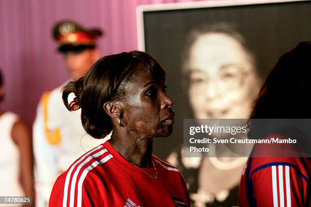 Ana Fidelia Quirot, former track and field world champion and Atlanta silver medal winner stands in line near a picture of Raul Castro's Wife, Vilma...