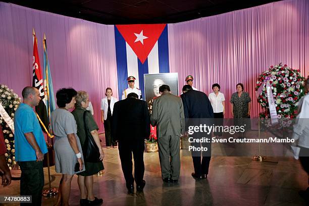 Cubans stand near a photo of Vilma Espin, wife of Cuba's acting President Raul Castro, that is displayed in the Memorial Jose Marti, at the...