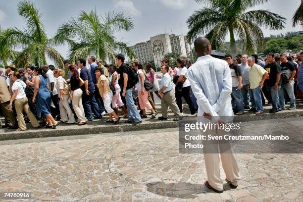 Cubans wait in line to pass by a photo of Vilma Espin, wife of Cuba's acting President Raul Castro, that is displayed in the Memorial Jose Marti, at...