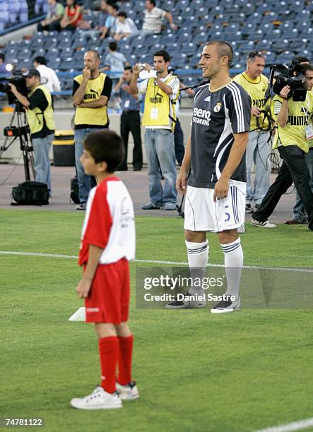 Fabio Cannavaro of Real Madrid stands on the pitch with a young player before a friendly match between Real Madrid and a Palestinian & Israeli XI at...