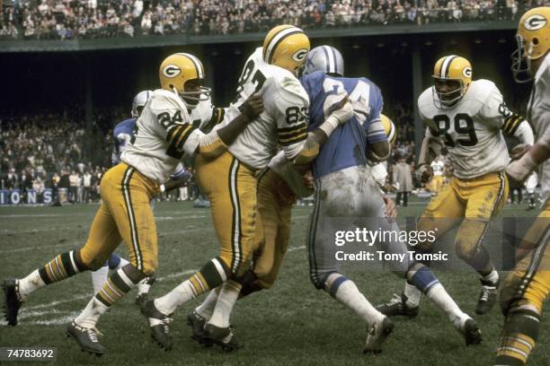 Defensiveback Willie Wood and defensive lineman Willie Davis of the Green Bay Packers stop runningback Mel Farr of the Detroit Lions during a game on...