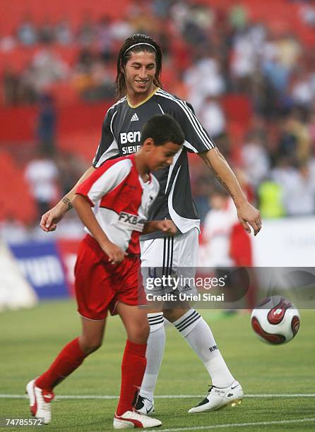 Sergio Ramos of Real Madridplays football with a young boy before the match between Real Madrid and a Palestinian & Israeli XI at the Ramat Gan...