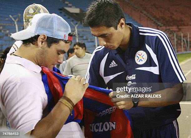 Oscar Cardozo firma autografos durante un reconocimiento del campo de juego de la seleccion paraguaya de futbol el 19 de junio de 2007 en el estadio...