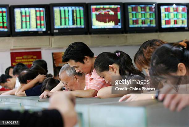 Investors view stock prices at a securities company on June 20, 2007 in Wuhan, China. Chinese stocks fell 2 percent from the 4,200-point mark today,...