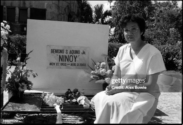 Philippine presidential candidate Corazon Aquino visits a cemetery on the outskirts of Manila to place flowers on the grave of her husband, statesman...