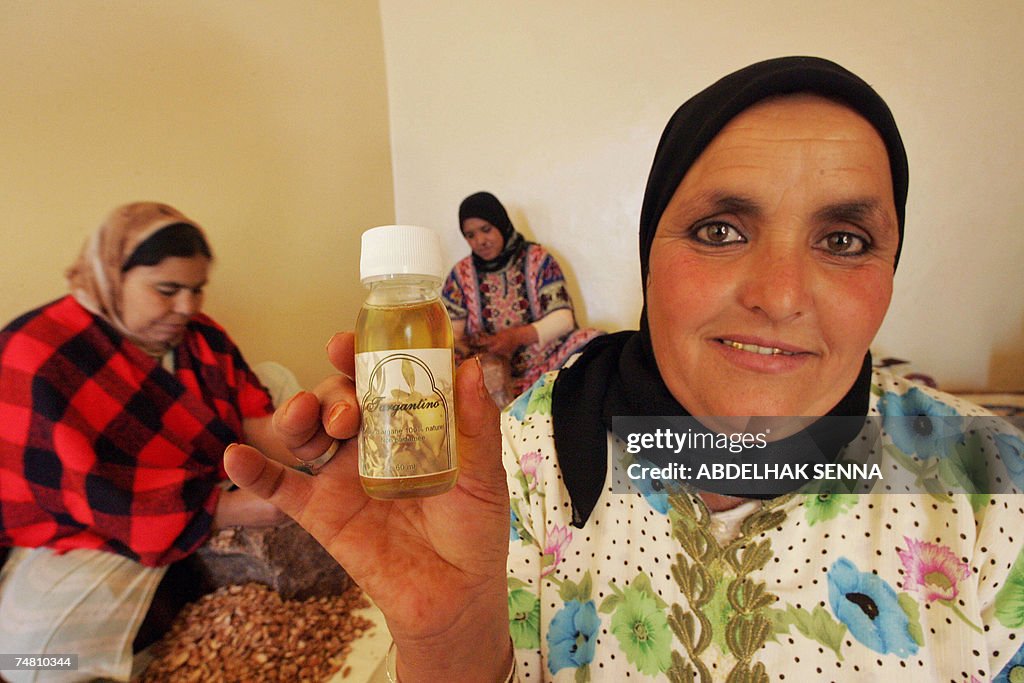 A Moroccan woman shows a flacon of Argan...