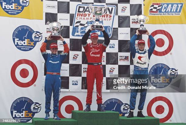 Scott Dixon of New Zealand, driver of the PacWest Lights Racing Lola T97/20 Buick holds the trophy aloft and celebrates alongside second placed...