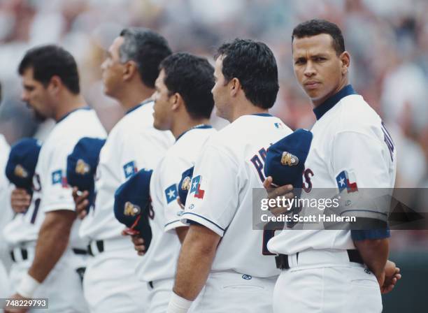 Alex Rodriguez of the Texas Rangers looks across as he stands in line with team mates Rafael Palmeiro, Ivan Rodriguez, Andras Galarraga and Ken...