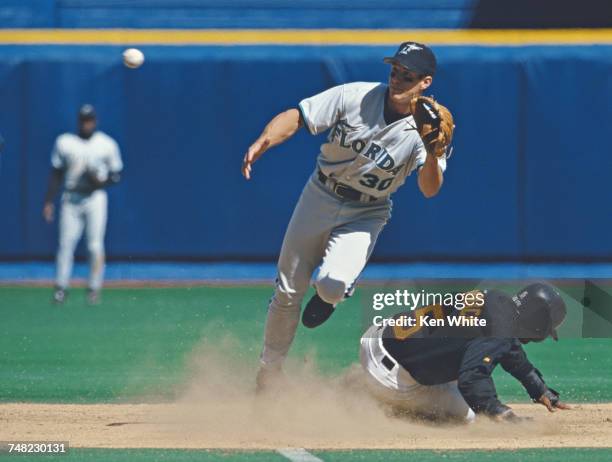Tony Womack of the Pittsburgh Pirates slides into second base as Craig Counsell of the Florida Marlins tries to tag him out during their Major League...