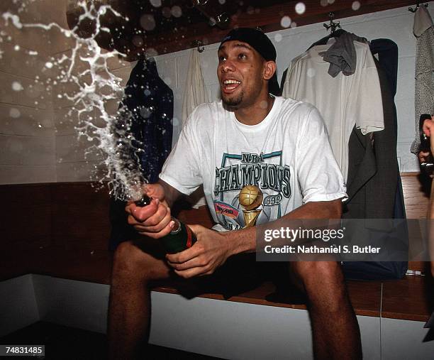 Tim Duncan of the San Antonio Spurs pops open a bottle of champaigne following Game Five of the 1999 NBA Finals at Madison Square Garden on June 25,...