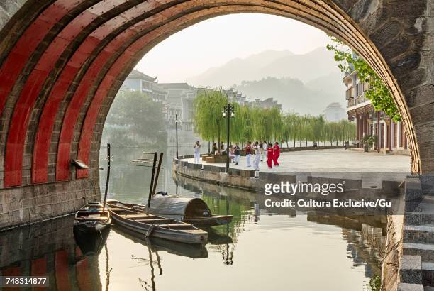large group of senior adults exercising on waterfront, zhenyuan, guizhou, china - cultura china stock-fotos und bilder