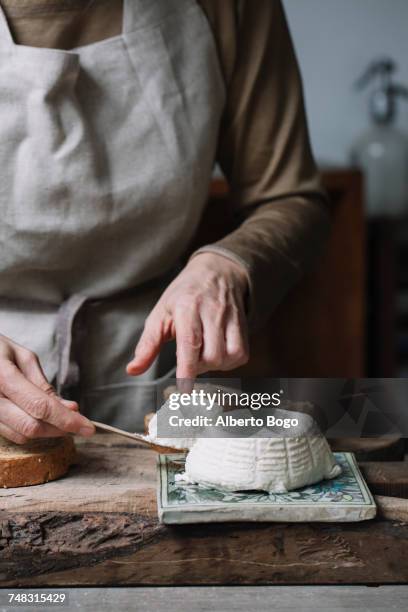 woman taking slice from whole ricotta, mid section - ricotta cheese stock pictures, royalty-free photos & images