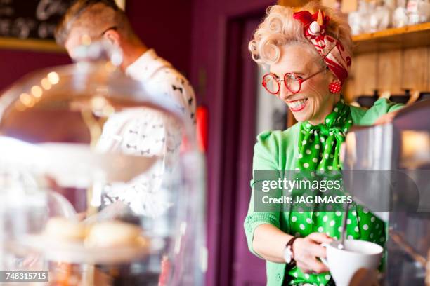 quirky vintage woman using coffee machine in tea room - couple in cafe man beard coffee stock-fotos und bilder