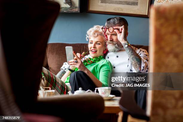 quirky vintage couple looking at smartphone in tea room - 1950s fashion stock pictures, royalty-free photos & images