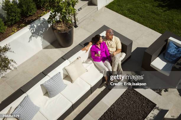 older couple relaxing on modern backyard patio - garden furniture stockfoto's en -beelden
