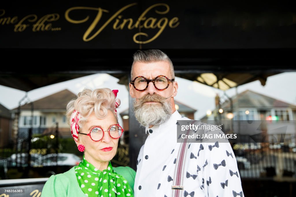 Serious portrait of a quirky vintage couple outside vintage shop