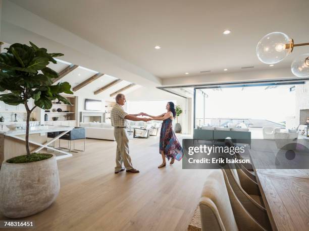 older couple dancing in modern home - couple dancing at home stockfoto's en -beelden