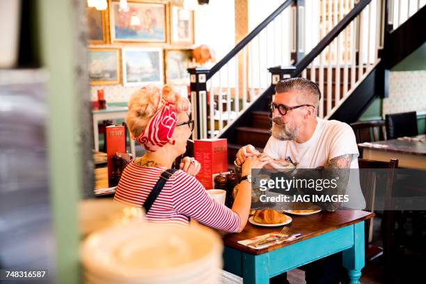 quirky couple relaxing in bar and restaurant, bournemouth, england - bar man t shirt ストックフォトと画像