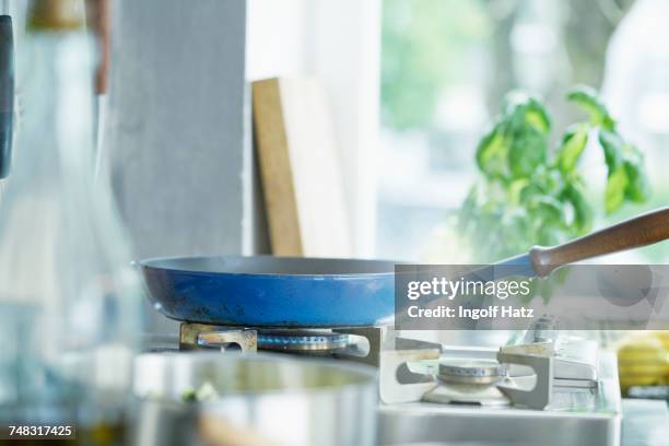 frying pan on lit hob - gas stove cooking stock pictures, royalty-free photos & images