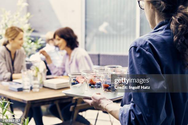 waitress serving dessert to businesswomen during business lunch outside office - smart casual lunch stock pictures, royalty-free photos & images