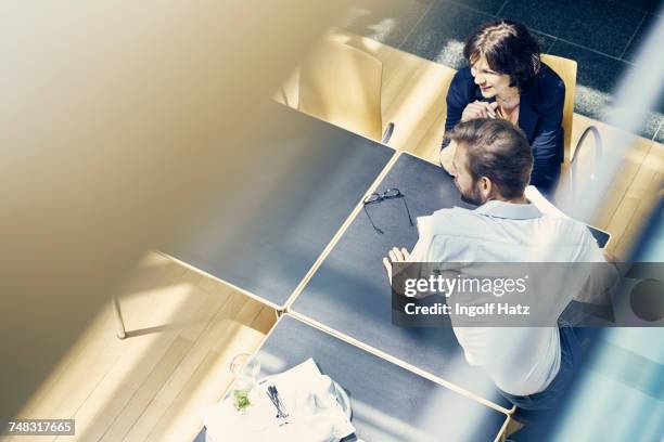 high angle window view of businesswoman and man looking over in office - 見渡す ストックフォトと画像