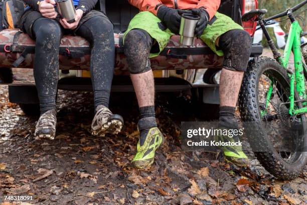 legs of caucasian couple sitting in pickup truck near bicycle - man touching womans leg stock pictures, royalty-free photos & images